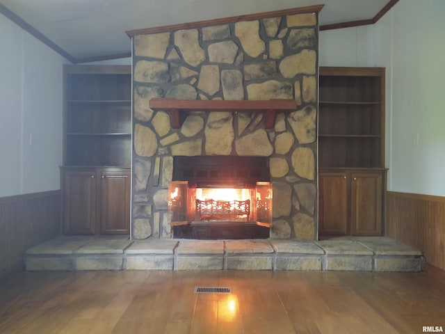 room details featuring hardwood / wood-style floors, a stone fireplace, and built in shelves