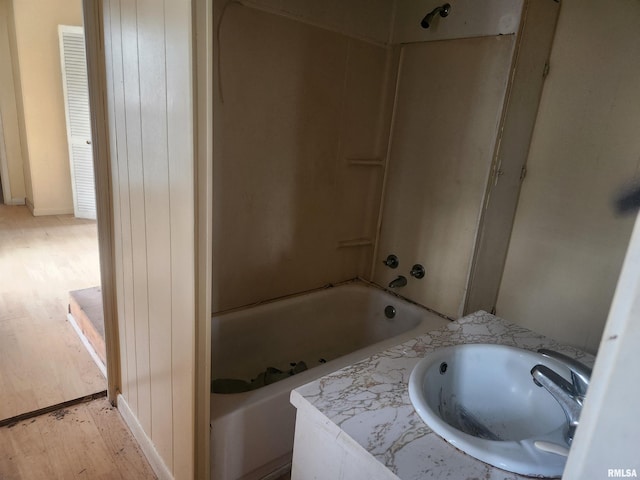 bathroom featuring hardwood / wood-style flooring, tub / shower combination, and sink