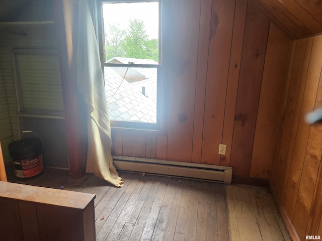 interior space featuring hardwood / wood-style flooring, a baseboard radiator, and wood walls