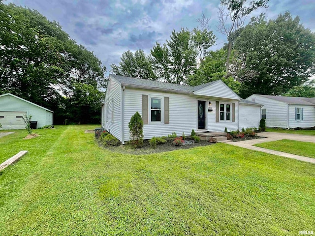 view of front of home with a front lawn, a garage, and an outdoor structure