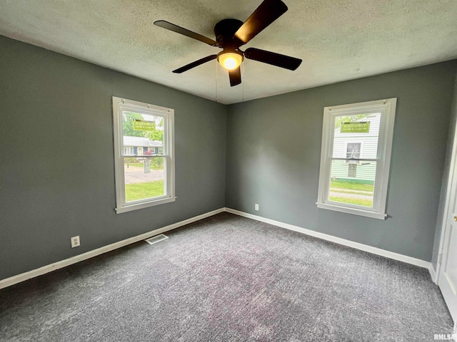 carpeted spare room with ceiling fan and a textured ceiling