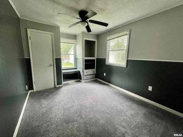 carpeted spare room featuring ceiling fan and a textured ceiling