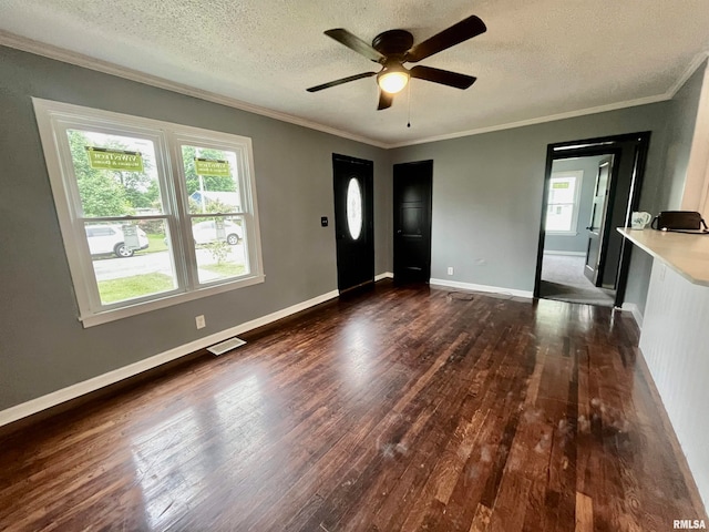 foyer entrance featuring ceiling fan, ornamental molding, dark hardwood / wood-style flooring, and a textured ceiling