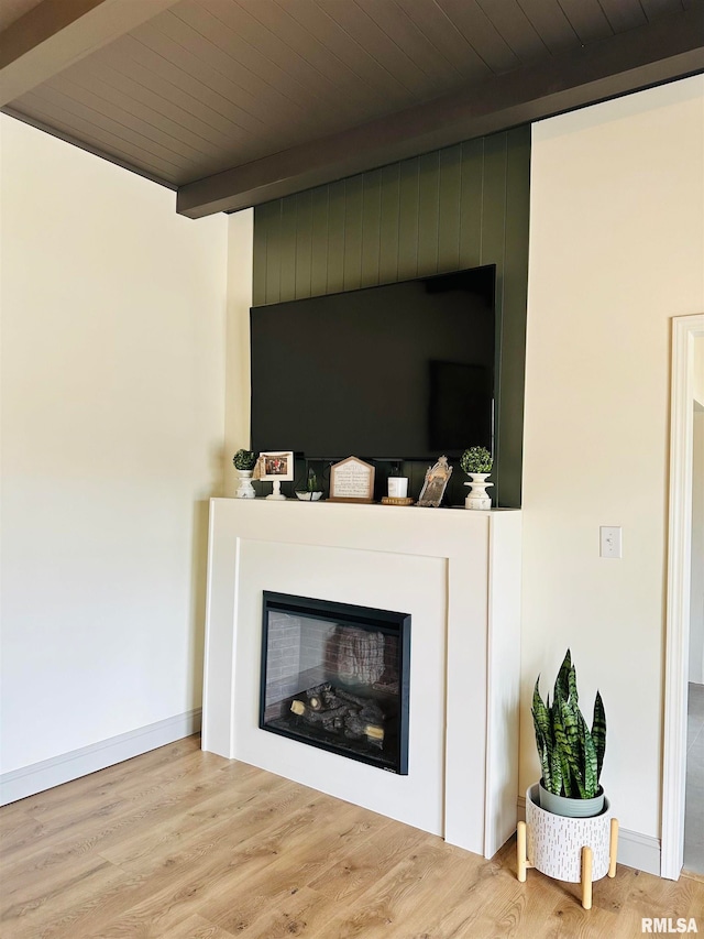 room details with beamed ceiling, light hardwood / wood-style floors, a fireplace, and wooden ceiling