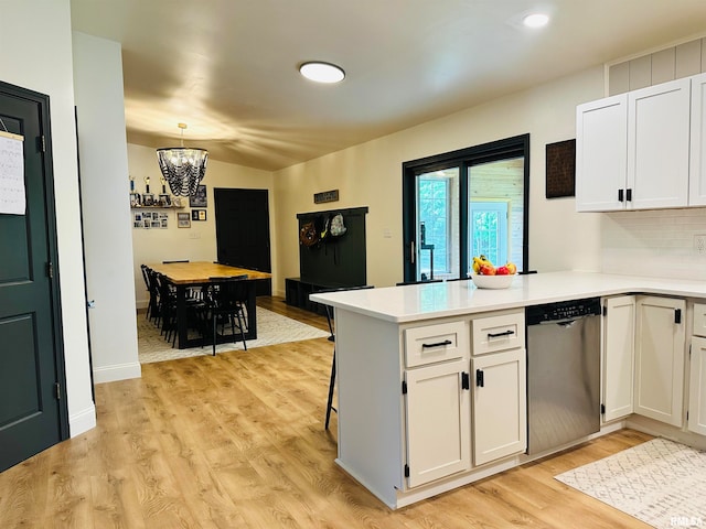 kitchen featuring kitchen peninsula, white cabinets, light hardwood / wood-style flooring, and stainless steel dishwasher