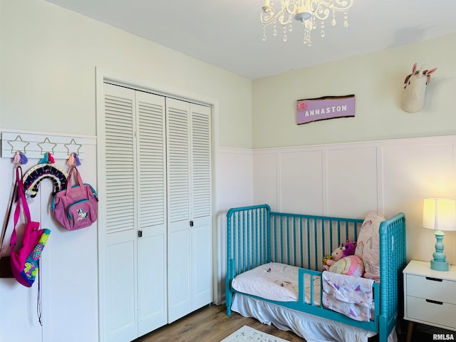 bedroom with wood-type flooring, a closet, and a chandelier