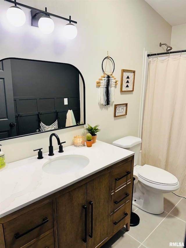 bathroom featuring toilet, tile floors, and large vanity