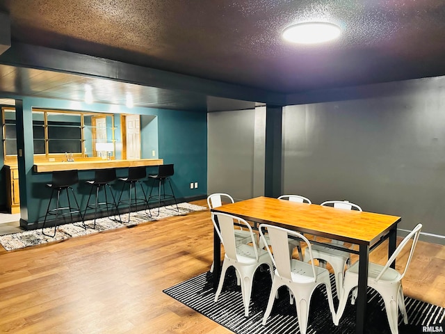 dining area with a textured ceiling and light wood-type flooring