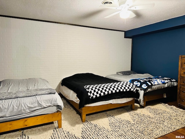 bedroom featuring hardwood / wood-style flooring, ceiling fan, and a textured ceiling