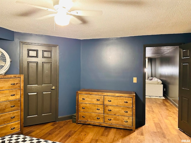 bedroom with ceiling fan, a textured ceiling, and hardwood / wood-style flooring