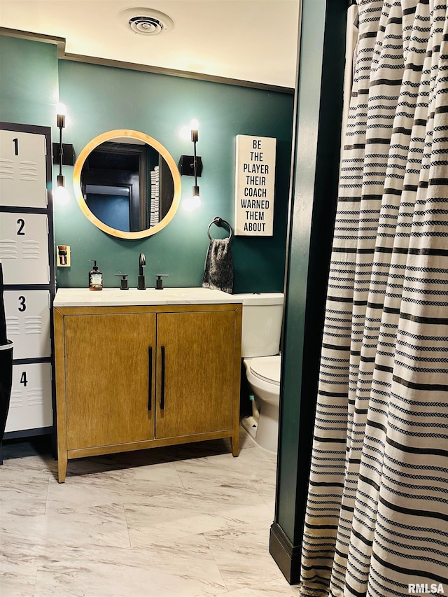 bathroom featuring tile flooring, toilet, and large vanity