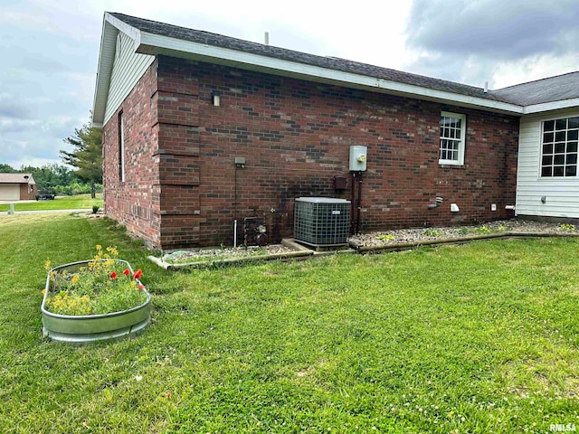 view of side of property with a yard and central AC unit