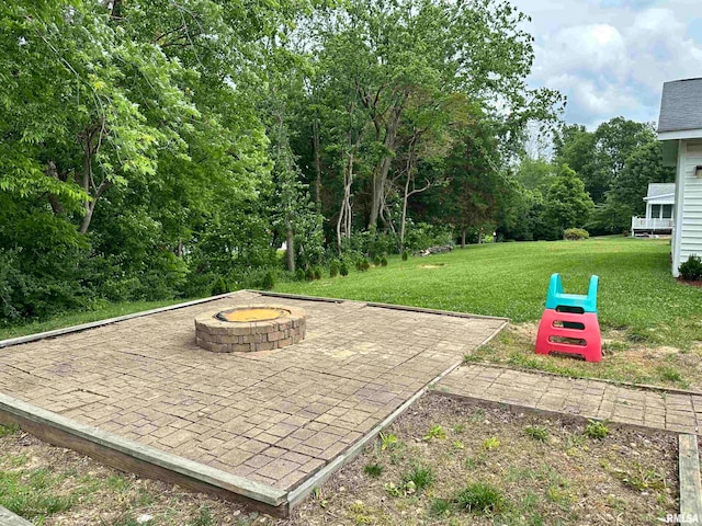 exterior space with an outdoor fire pit, a lawn, and a patio