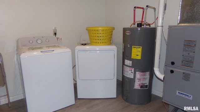 laundry area with water heater, washing machine and dryer, heating unit, and hardwood / wood-style floors