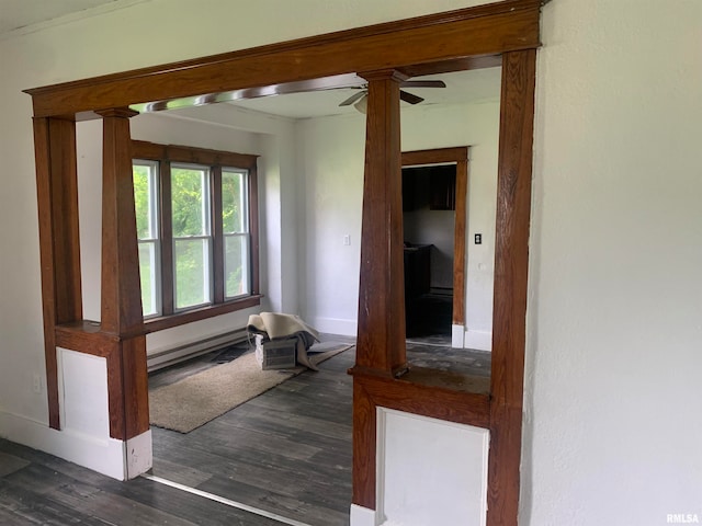 hall featuring dark hardwood / wood-style floors, baseboard heating, and ornate columns