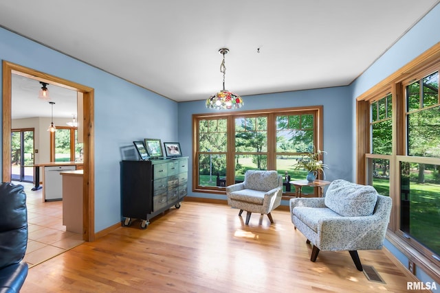 living area featuring an inviting chandelier, light tile flooring, and a wealth of natural light