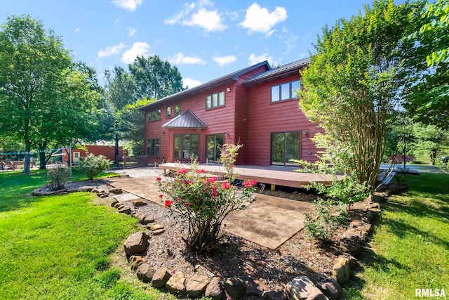 rear view of property featuring a yard and a wooden deck