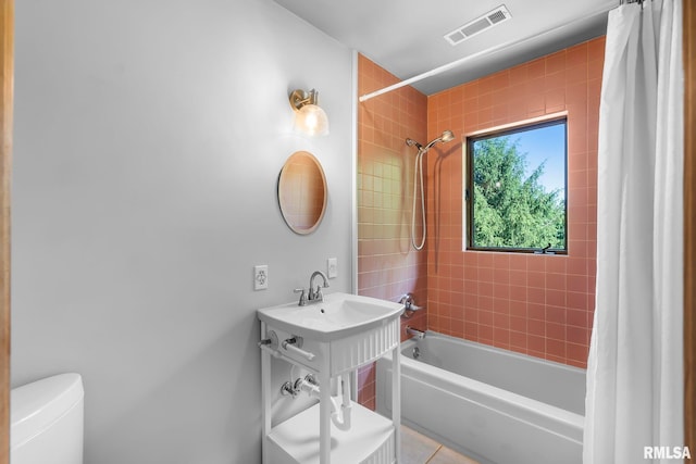 full bathroom featuring sink, shower / bath combination with curtain, toilet, and tile floors