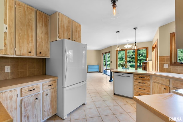 kitchen with hanging light fixtures, white appliances, backsplash, sink, and light tile floors