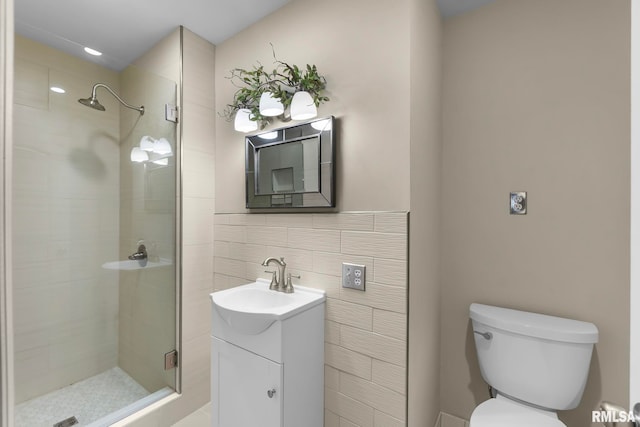 bathroom featuring a tile shower, toilet, and vanity with extensive cabinet space