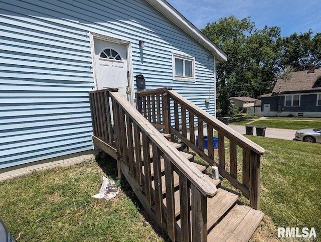 view of exterior entry with a yard