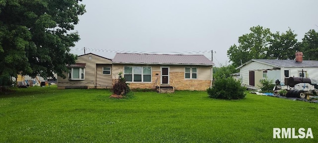 108 N Spencer St, Mounds, IL 62964 - back of property featuring a lawn, metal roof, and stone siding