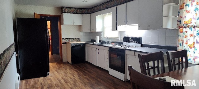 108 N Spencer St, Mounds, IL 62964 - kitchen with black appliances, wallpapered walls, a sink, wood finished floors, and decorative backsplash