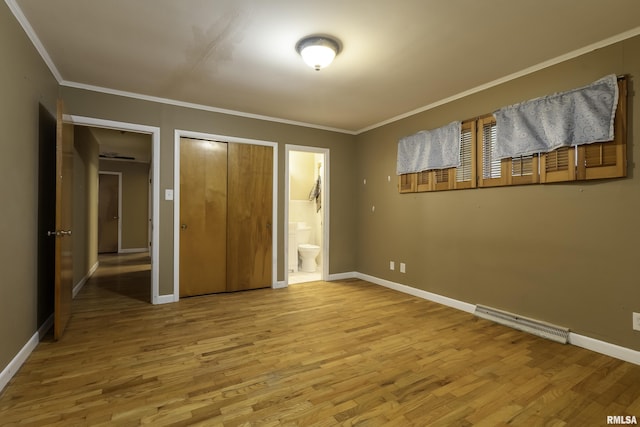 unfurnished bedroom with ensuite bath, ornamental molding, and wood-type flooring