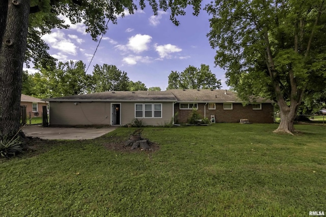 rear view of property featuring a yard and a patio area