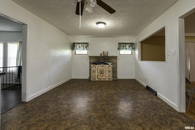 unfurnished living room featuring a textured ceiling and ceiling fan