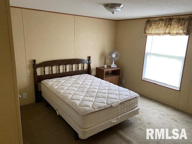 bedroom featuring a textured ceiling and carpet flooring