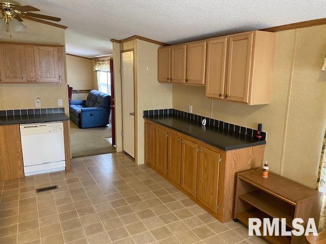 kitchen featuring a textured ceiling, light tile flooring, ceiling fan, and white dishwasher