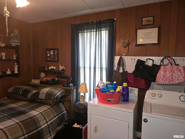 bedroom with wood walls and independent washer and dryer