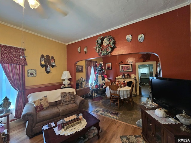 living room featuring a healthy amount of sunlight, wood-type flooring, and ornamental molding