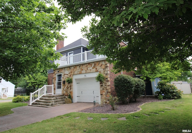 view of front of property with a balcony, driveway, stone siding, a chimney, and a front yard