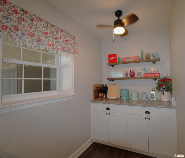 bar featuring ceiling fan, dark wood-type flooring, and baseboards