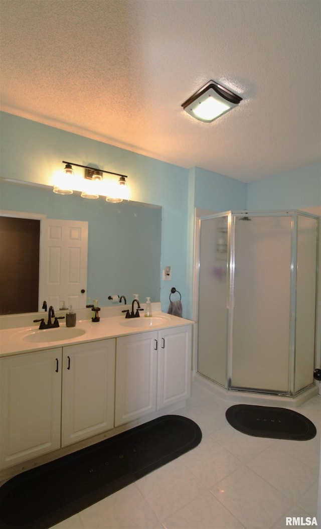 bathroom with double vanity, a stall shower, and a sink