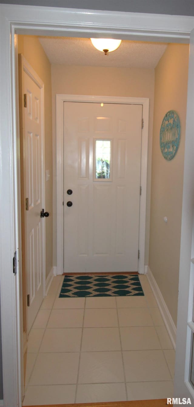 entryway featuring light tile patterned flooring and baseboards