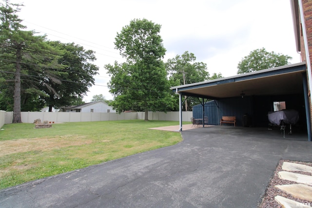 view of yard with driveway and fence