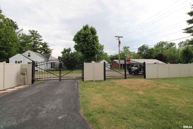 view of gate with a yard and fence