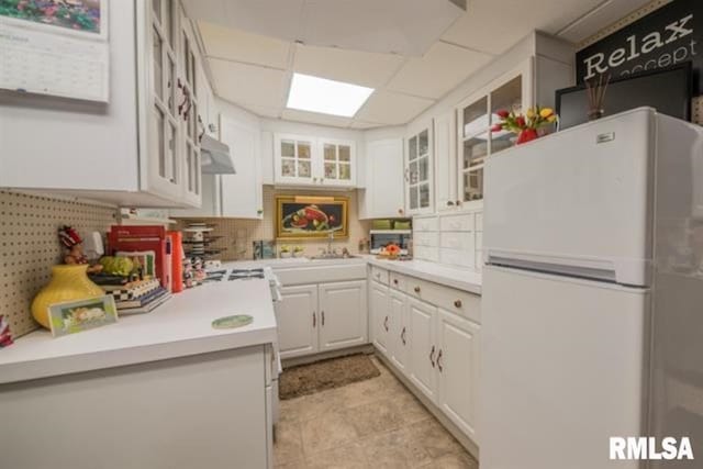 521 S Park Ave, Herrin, IL 62948 - kitchen with freestanding refrigerator, light countertops, white cabinetry, and glass insert cabinets