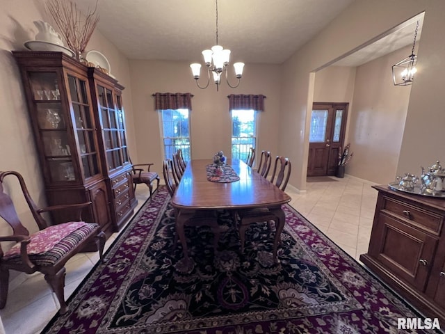 dining space with light tile patterned floors, a textured ceiling, and an inviting chandelier