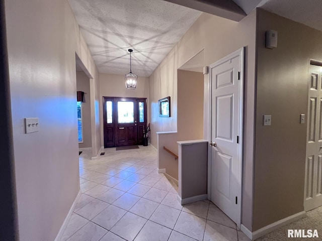 hallway featuring a textured ceiling and light tile patterned flooring