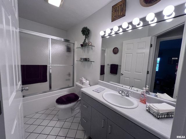 full bathroom with tile patterned flooring, vanity, toilet, and bath / shower combo with glass door