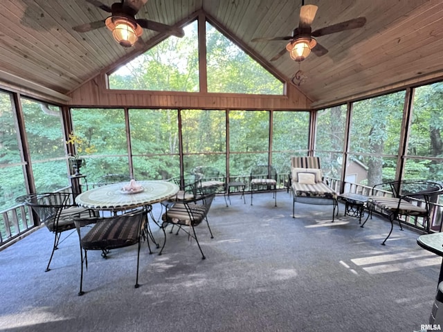 unfurnished sunroom featuring ceiling fan, a healthy amount of sunlight, wooden ceiling, and vaulted ceiling