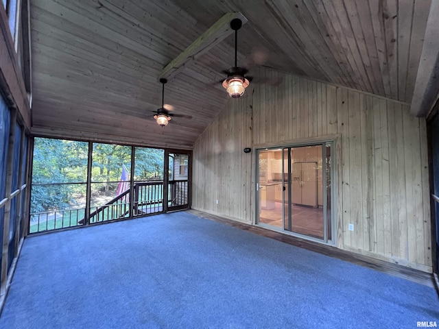 empty room featuring carpet, lofted ceiling with beams, ceiling fan, and wood ceiling