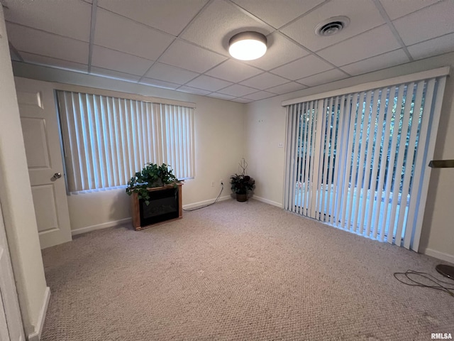 carpeted spare room with a paneled ceiling