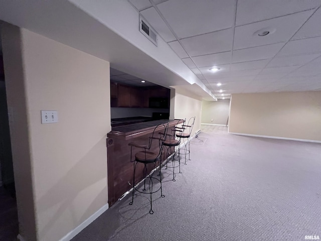 bar with a paneled ceiling and carpet floors