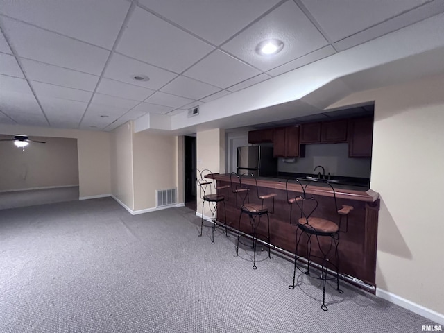 kitchen with carpet flooring, sink, a drop ceiling, and fridge