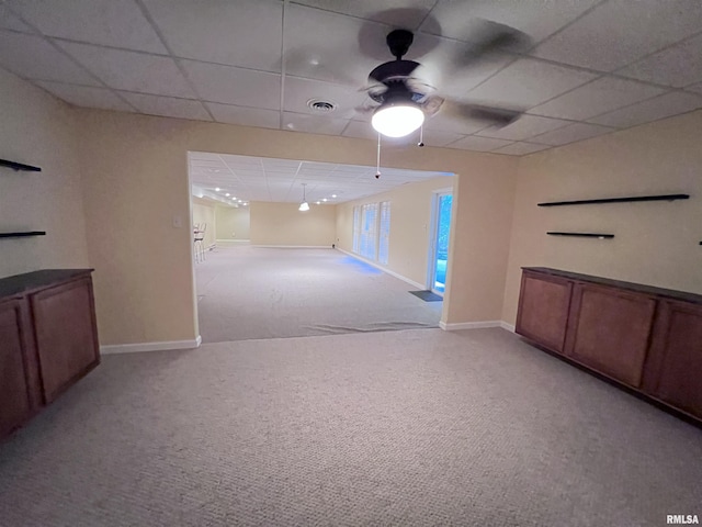 carpeted empty room featuring a drop ceiling and ceiling fan